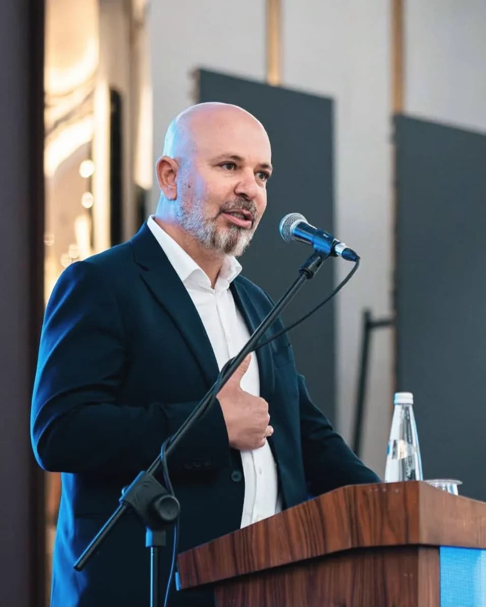 Koral Bozkurt, kürsüde elini göğsüne koyarak konuşurken